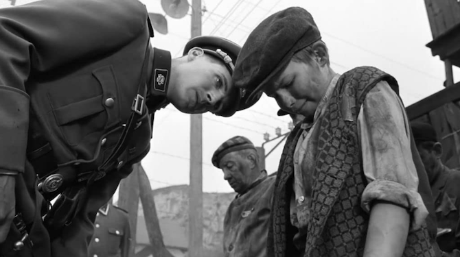 A black-and-white scene from Schindler’s List where Amon Goeth (played by Ralph Fiennes) chastises a child prisoner.