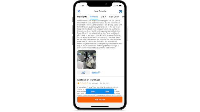 The Chewy app allows reviewers to upload pictures of the products they bought. The Item Details tab for this doggy car seat shows a small white dog lying down inside a hanging bucket seat.