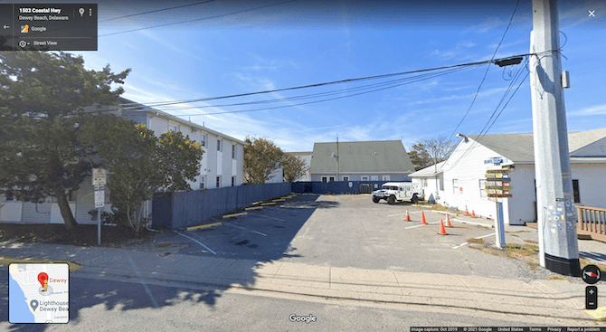 A Google Maps search for the Dewey Beach Town Hall shows this view of an empty parking lot and a small white building beside it.