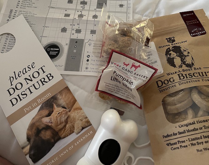 The East Bay Inn of Savannah, GA provides guests with a goody bag of dog treats from places like Oliver Bentleys and Woof Gang Bakery and poop bag supplies. A Please Do Not Disturb - Pet in Room sign and a map of Savannah were also provided.