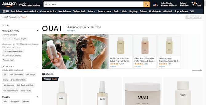 In Amazon search results for the brand “OUAI”, a wide promotional banner appears beside the company’s products. The banner shows someone holding one of OUAI’s shampoo bottles against a jungle backdrop. Beside it is an image of a tanned woman shampooing her long brown hair.