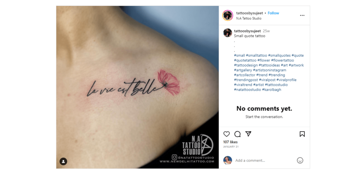 From the Instagram page of @tattoosbysujeet is an example of a text-based tattoo. It reads “la vie est belle”. The end of the cursive “e” at the end turns into the stem of a flower with a red rose petal emerging from it.