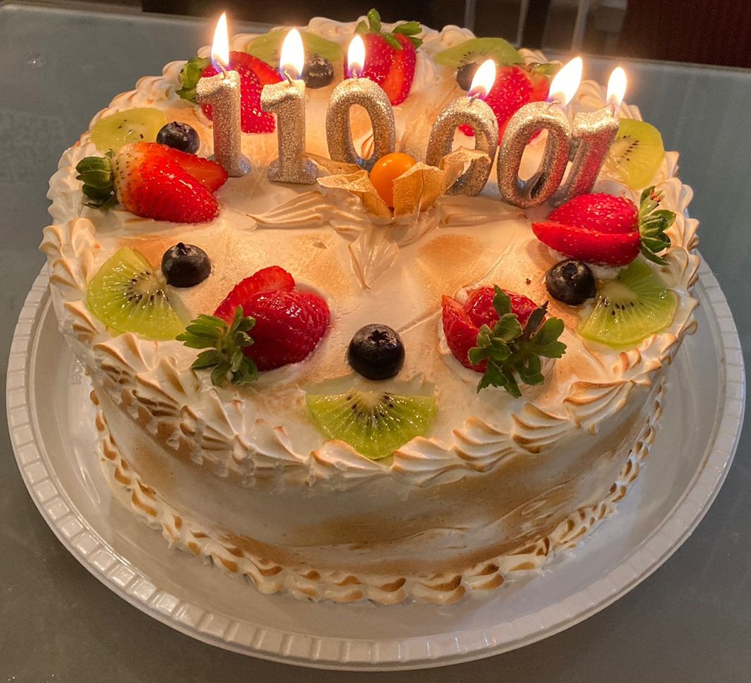 A cake with 110001 candles, fruit and toasted icing