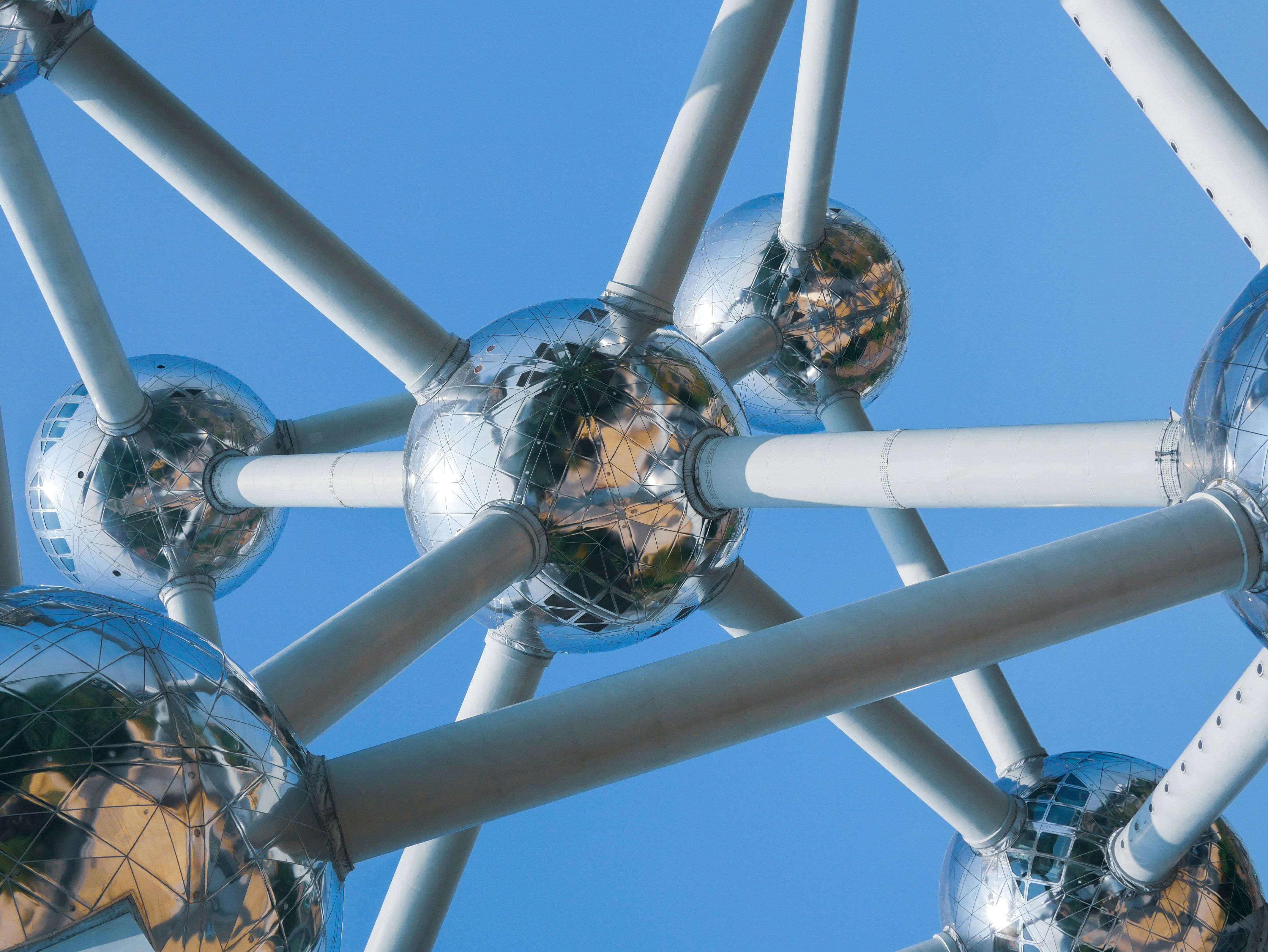 A closeup of a sculpture showing metal orbs connected with cylindrical tubes