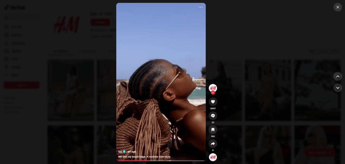 On H&M’s TikTok page is a video of a woman wearing sunglasses. She lies back on a brown bag with the ocean behind her. The caption reads: “Me and my beach bags. A love story.”