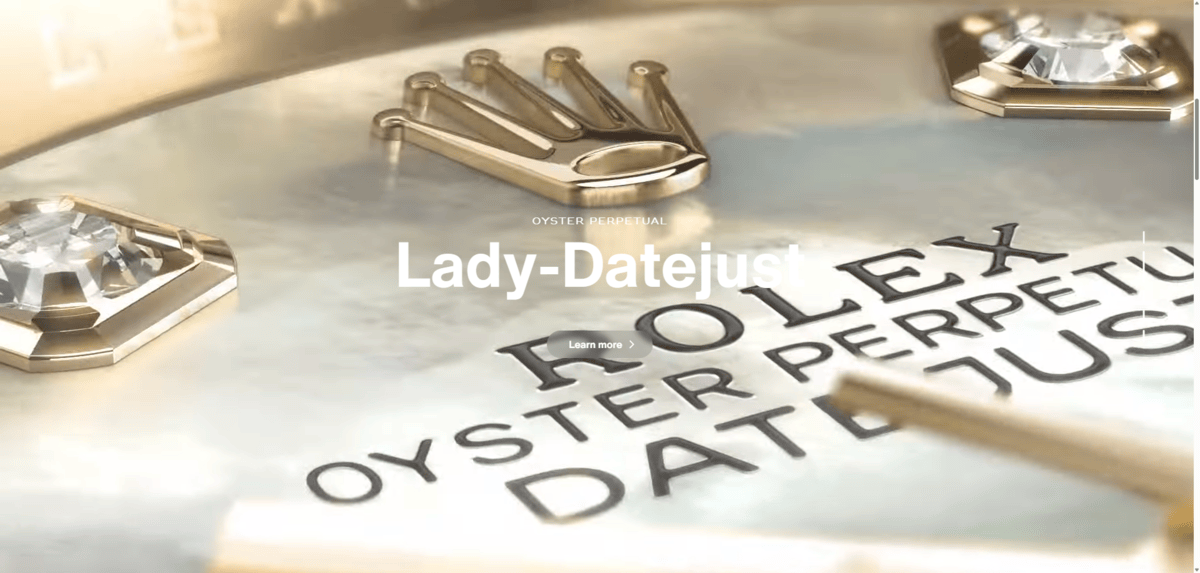 On the homepage of the Rolex website, there is a vertical video scroller. In this screenshot, we see a gold Rolex background with the headline “Lady-Datejust” on top of it along with a “Learn more” button.